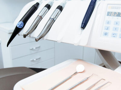 Dental instruments and handpieces on a treatment tray at a dental chair